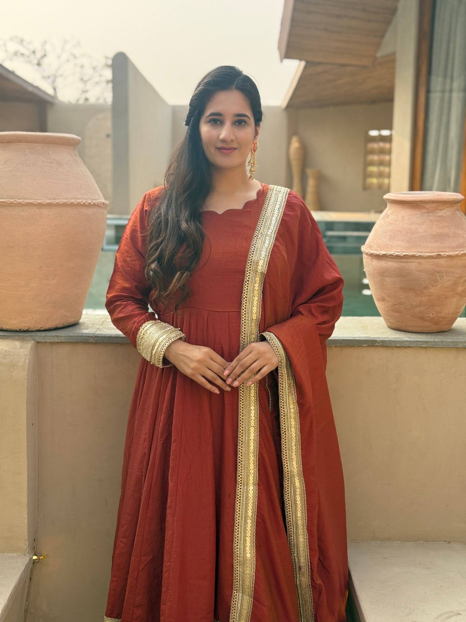 Regal Rust Orange Flared Anarkali Suit Set Featuring Ornate Gold Sequined Borders, a Scalloped Neckline, and an Elegant Tie-Up Back